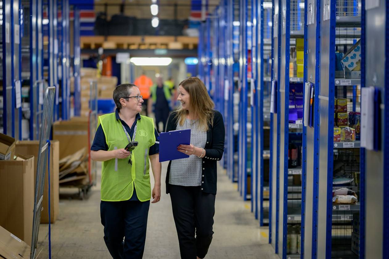 Ondernemer en medewerker overleggen in een magazijn